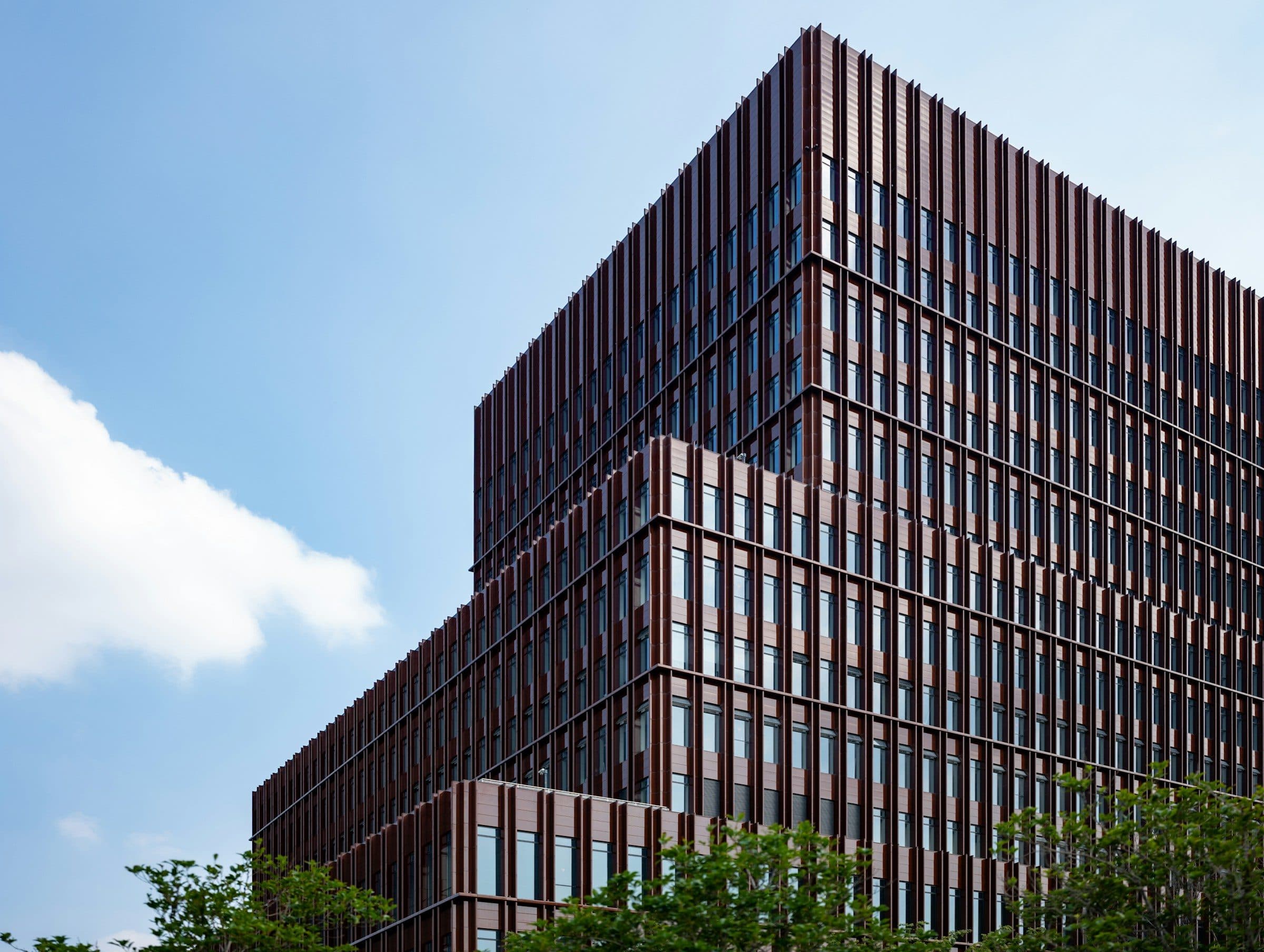 A brick-clad office block, its roofline corner against the sky
